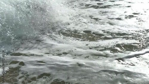 Slow motion shooting of splashing waves, water surface texture in the glare of the sun