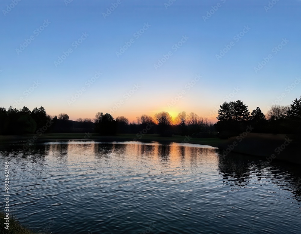 Obraz premium Sunset over a tranquil pond