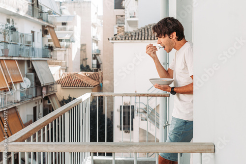 Young man eating cereal on the terrace of Athens apartment