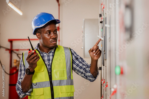 Electrical engineer working in control room. Electrical engineer man checking Power Distribution Cabinet in the control room