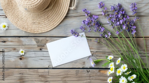 Fototapeta Naklejka Na Ścianę i Meble -  Minimal flat lay composition of daisy lavender flowers straw hat and blank card on wooden background Summer style with space for text