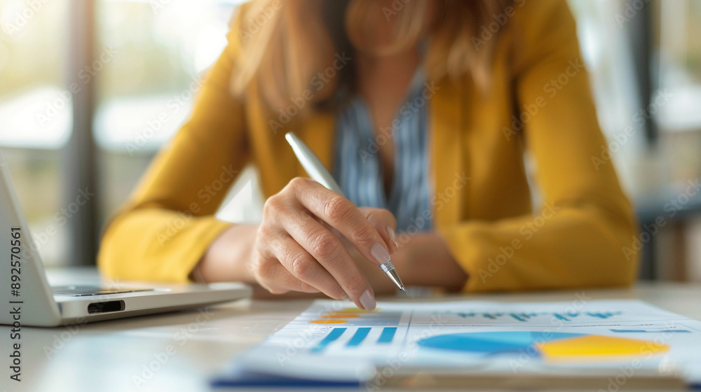 close up of a female business person holding a pen while reading papers close up of a female business person holding a pen while reading papers