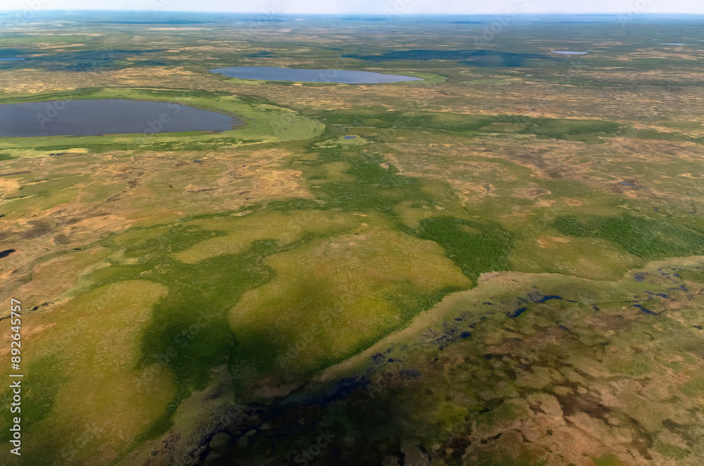 Arctic tundra in summer from an altitude of 2000 meters. Cloudy sky. Variety of colors and landscapes. The vastness of pristine nature. Shadow from the clouds Arctic tundra in summer from an altitude of 2000 meters. Cloudy sky. Variety of colors and landscapes. The vastness of pristine nature. Shadow from the clouds