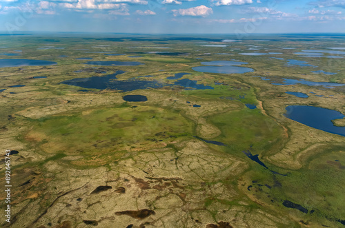 Arctic tundra in summer from an altitude of 2000 meters. Cloudy sky. Variety of colors and landscapes. The vastness of pristine nature. Shadow from the clouds