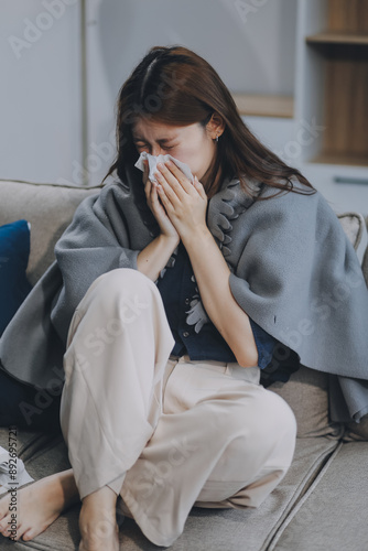 A woman with a cold with pills is treated at home chooses which drugs to take and self-medicates, checks the expiration date while sitting on the couch at home