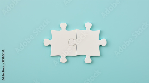 two white puzzle pieces matching together againt light blue background photo