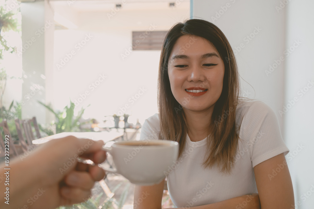 Asian woman is receiving a coffee cup and drink. Asian woman is receiving a coffee cup and drink.