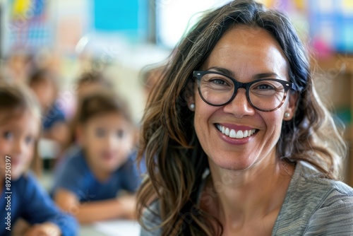 Wallpaper Mural Beautiful female teacher in glasses smiling and looking into camera at elementary school with children at the blurred background Torontodigital.ca
