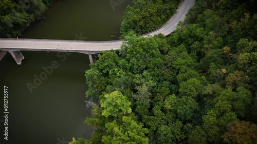 A pickup truck driving on the bridge over the Kentucky River between Harrodsburg and Lexington. Drone top-down view of the valley near the Kentucky River, showcasing the road connecting the cities. photo