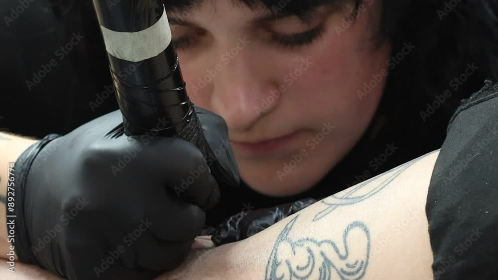 Primer plano de mujer tatuadora trabajando en el salón de tatuaje