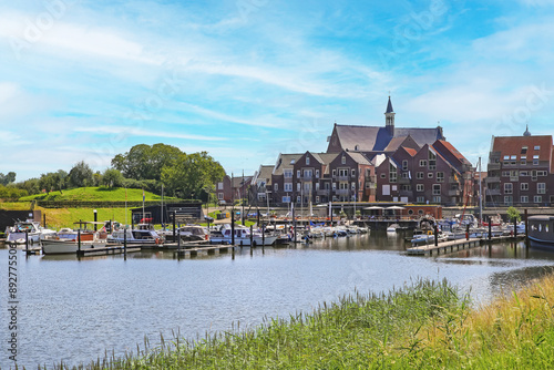 Grave, Netherlands (Noord-Brabant) - July 9. 2024: Beautiful inland harbor along cycle path at river Maas with cityscape of old dutch town