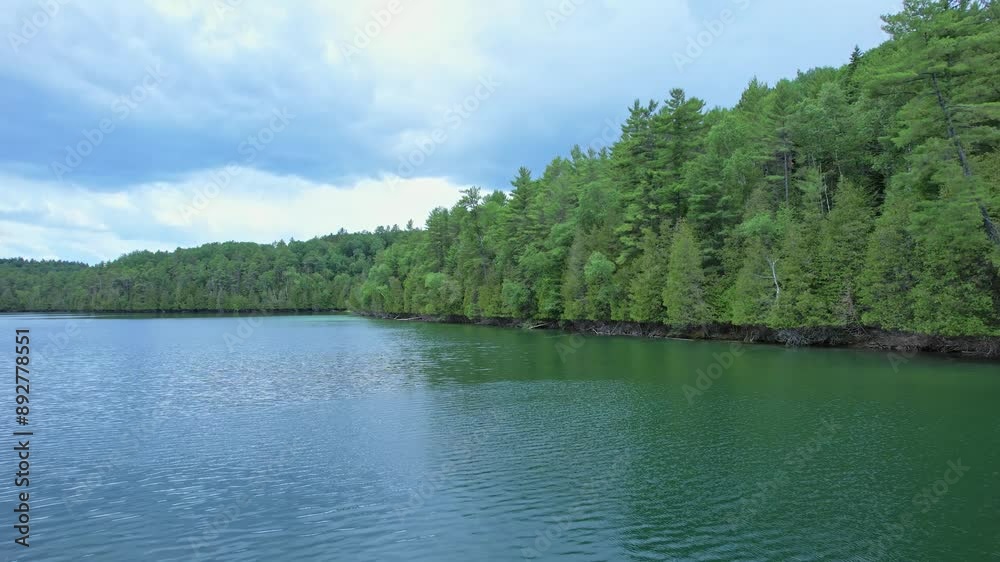 Picturesque rocky turquoise blue lake surrounded by dense pine forests, remote dangerous routs. Epic drone view of calm water. Top view of wild natural lake in Ontario, Canada, Crown land wilderness. Picturesque rocky turquoise blue lake surrounded by dense pine forests, remote dangerous routs. Epic drone view of calm water. Top view of wild natural lake in Ontario, Canada, Crown land wilderness.