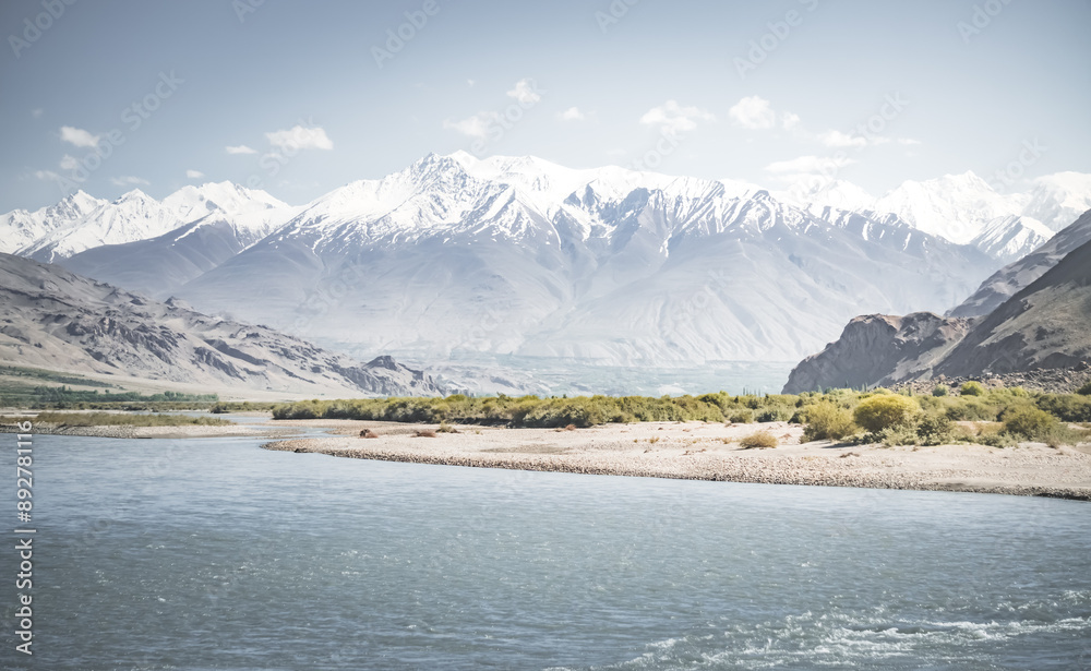 Obraz premium Panoramic landscape in Tien Shan mountains in Pamir with Panj river and mountains in Afghanistan and Tajikistan, sunny morning landscape for background