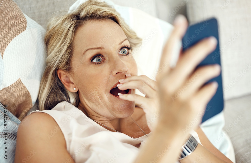 Mature woman, phone and surprise on couch with shock for reading, contact or announcement on mobile app in lounge. Person, chat and smartphone for social network, news and wow on sofa in house Mature woman, phone and surprise on couch with shock for reading, contact or announcement on mobile app in lounge. Person, chat and smartphone for social network, news and wow on sofa in house