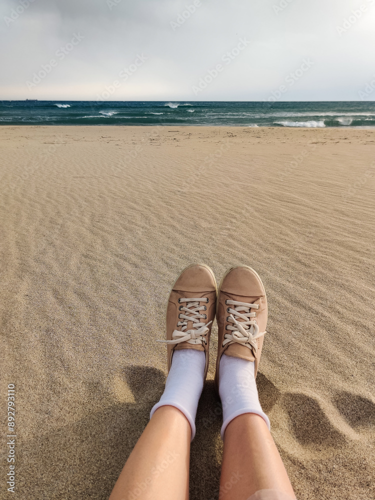 Fototapeta premium close up of feet in shoes on the beach