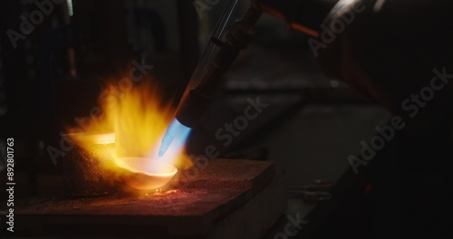 Fotografie Goldsmith melting gold in crucible with blow torch