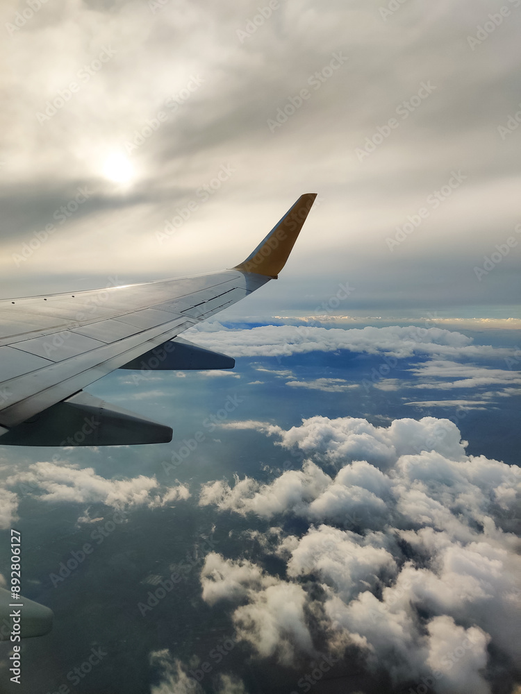 Fototapeta premium beautiful thick clouds in the sky from the height of the flight of the plane with a view of the wing with engines
