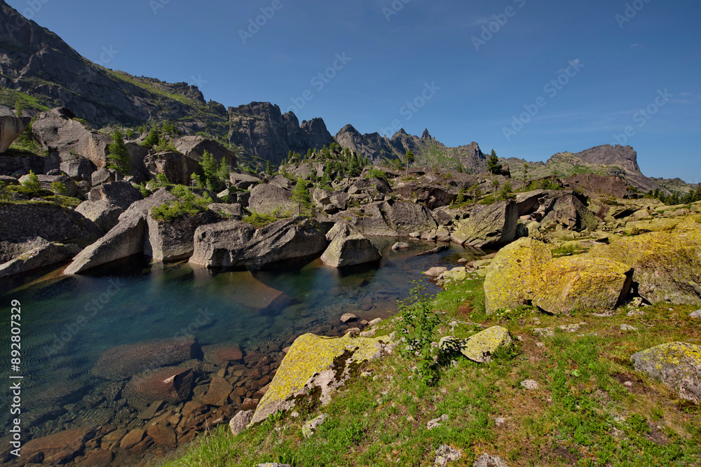 Fototapeta premium Russia. The South of Siberia. Western Sayan. Panoramic view of the alpine lake Harmony, surrounded by the harsh cliffs of the Ergaki Natural Mountain Park.