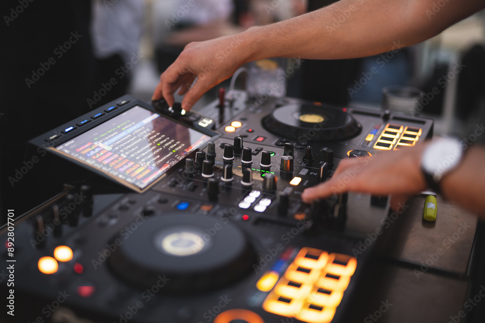 Naklejka premium a DJ plays music on a controller at a party
