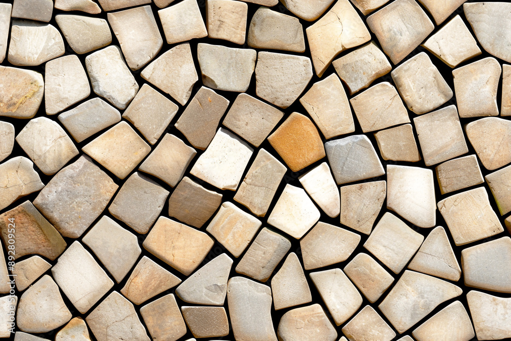 Wall made from irregular pieces of light brown sandstone. Concept of natural stone, cladding, and textured backgrounds. Wall made from irregular pieces of light brown sandstone. Concept of natural stone, cladding, and textured backgrounds.