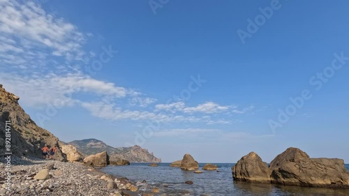 Time laps of movement of water and clouds in a rocky sea landscape on a sunny day, view of the extinct volcano Kara-Dag