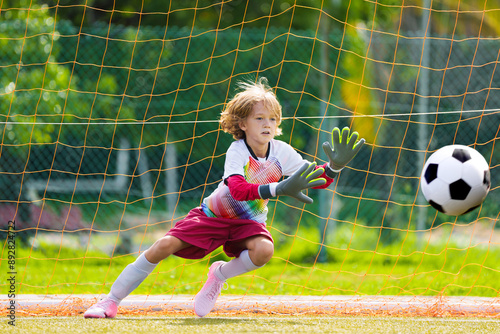 Quadro su tela Child playing football. Kids play soccer.