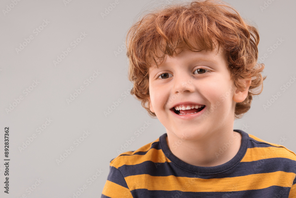 Portrait of cute little boy on grey background, space for text Portrait of cute little boy on grey background, space for text