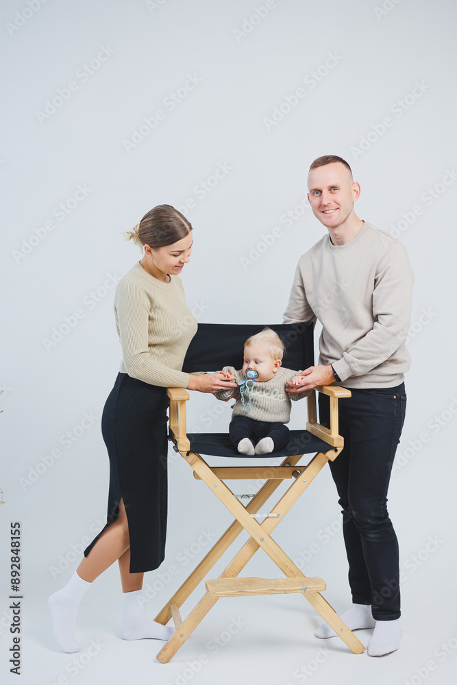 A happy family couple with a child. Young family mom dad and little baby smiling on white isolated background, loving married couple with baby. A happy family couple with a child. Young family mom dad and little baby smiling on white isolated background, loving married couple with baby.