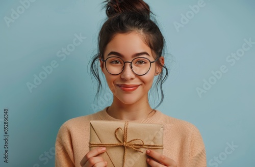 Woman Holding Gift In Front of Blue Background