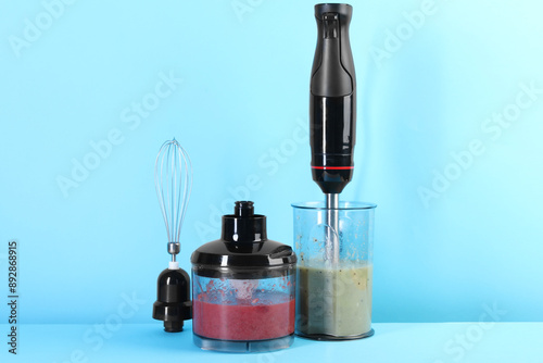 Hand blender kit and mixtures of ingredients on light blue background