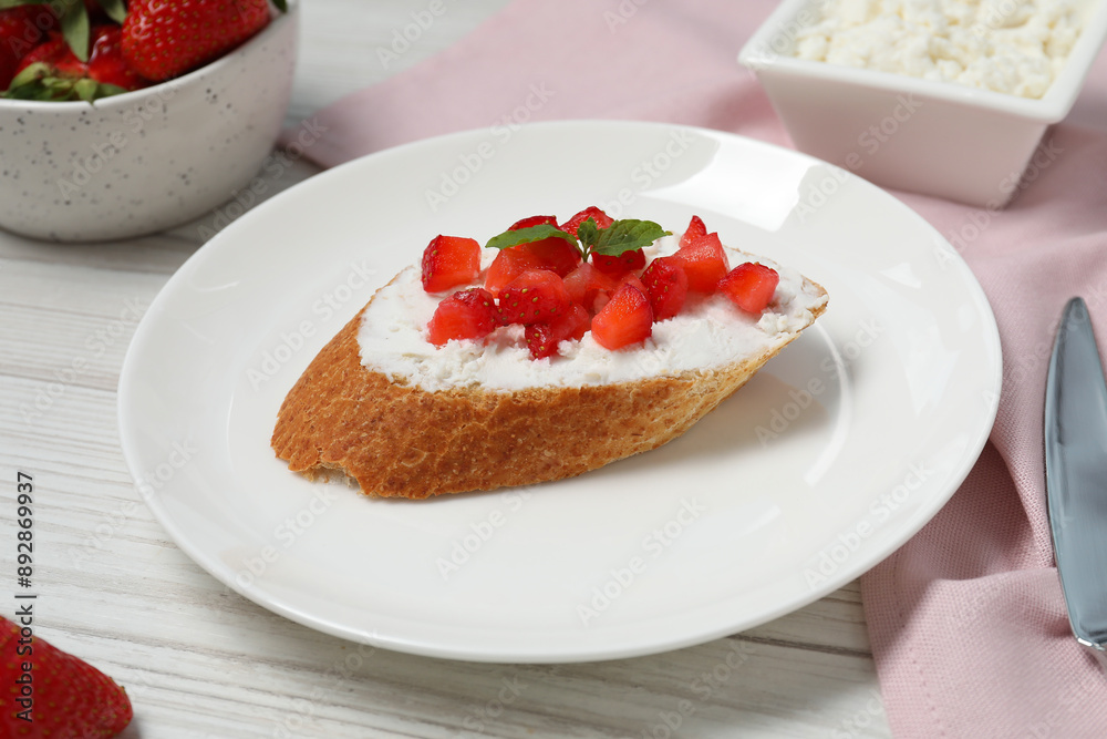 Delicious ricotta bruschetta with strawberry and mint on white wooden table Delicious ricotta bruschetta with strawberry and mint on white wooden table