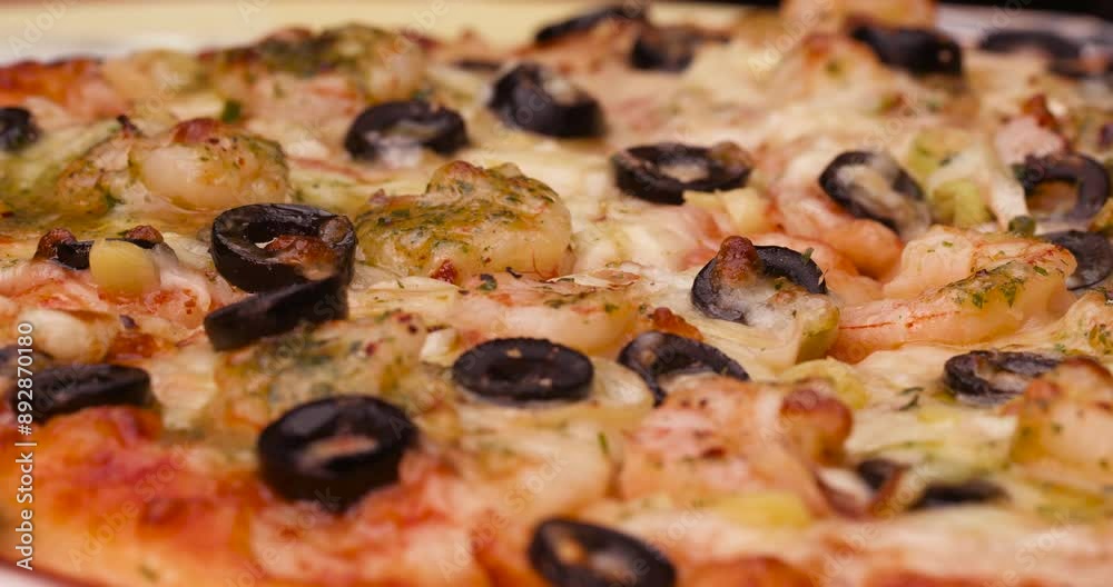 Medium shot of pizza with prawns and black olives. Medium shot of pizza with prawns and black olives.