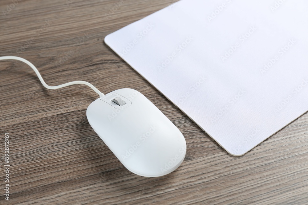 Computer mouse with mousepad on wooden desk, closeup Computer mouse with mousepad on wooden desk, closeup