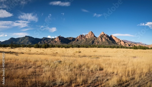 large panoramic shot of rocky mountain range with open field on clear day in rural new mexico