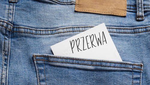 Wallpaper Mural White card with a handwritten inscription "Przerwa", inserted into the pocket of blue pants jeasnow (selective focus), translation: Break Torontodigital.ca