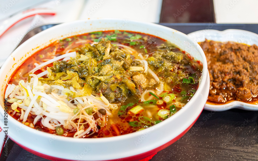Chinese rice noodle soup in red chili soup topped with pickled vegetables and pork mince aside Chinese rice noodle soup in red chili soup topped with pickled vegetables and pork mince aside