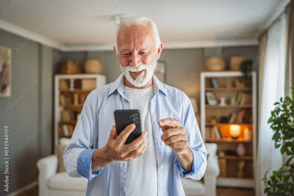 Portrait of senior man stand and use mobile phone at home Portrait of senior man stand and use mobile phone at home