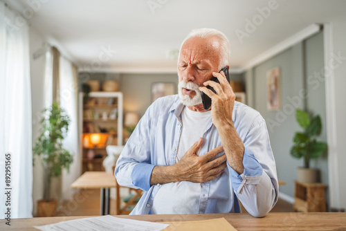 Tableau sur toile Senior man sit at home have a phone call while receive bad report