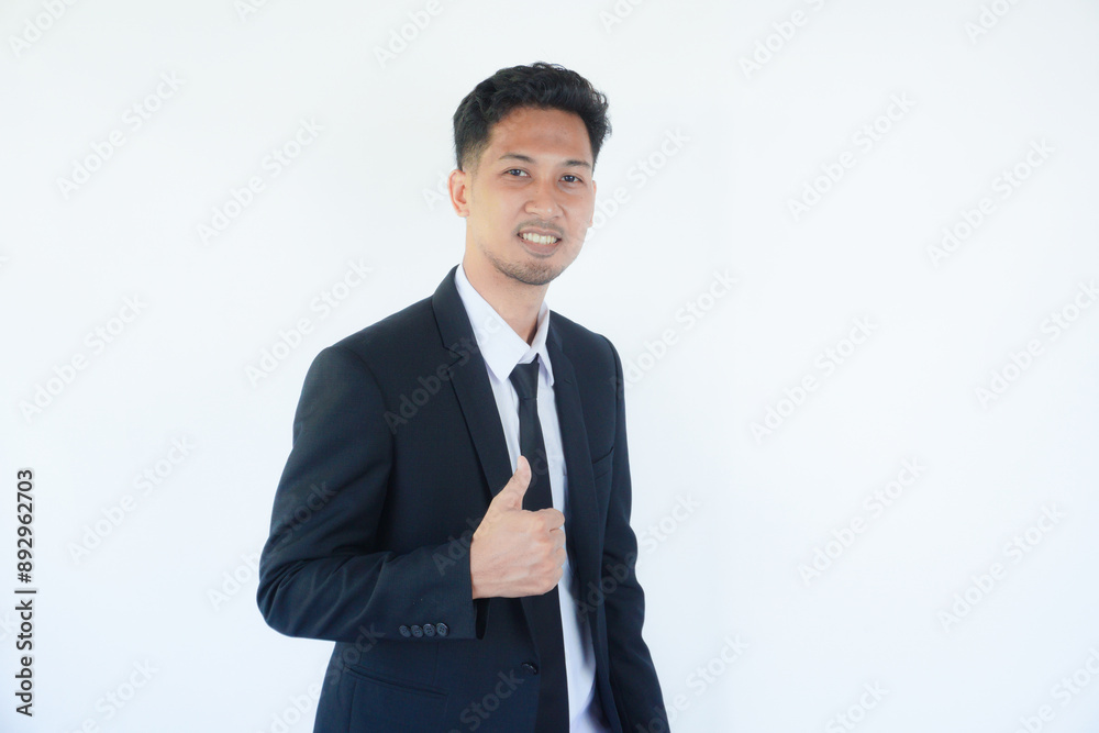 Adult Asian man wearing black suit and tie giving thumb up with happy expression Adult Asian man wearing black suit and tie giving thumb up with happy expression
