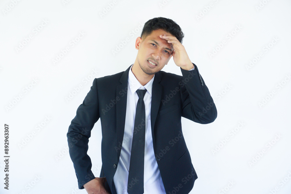 Adult Asian man wearing black suit and tie showing sad expression Adult Asian man wearing black suit and tie showing sad expression