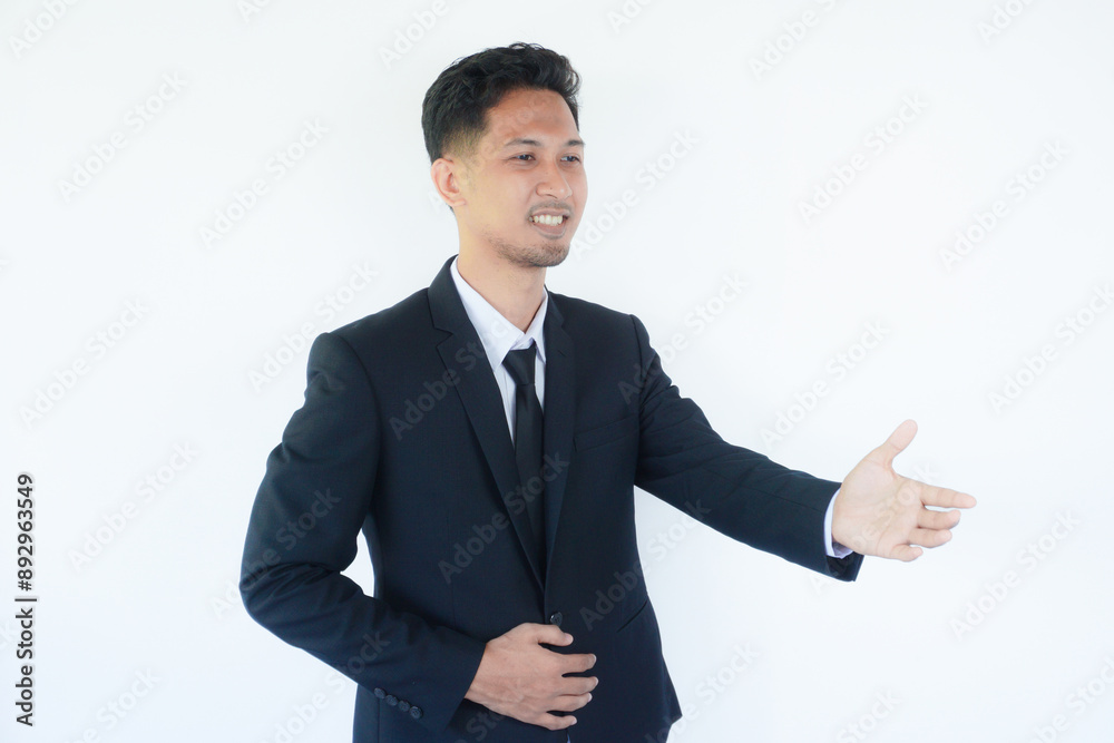 Adult Asian man wearing black suit and tie doing hand shake gesture for agreement Adult Asian man wearing black suit and tie doing hand shake gesture for agreement