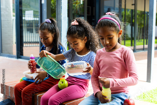 Three students share lunch, showing joy and diversity