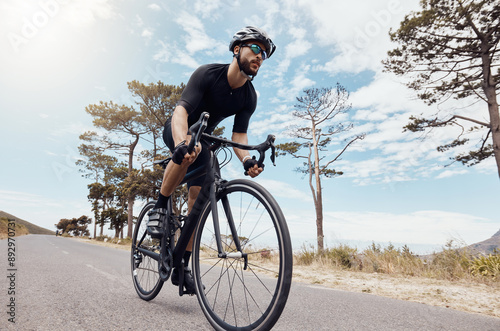 Fototapeta Naklejka Na Ścianę i Meble -  Road, cyclist or man in speed for training, competition and cycling race with endurance in Denmark. Outdoor, athlete and helmet for safety, fitness wellness and bike for sports adventure with energy