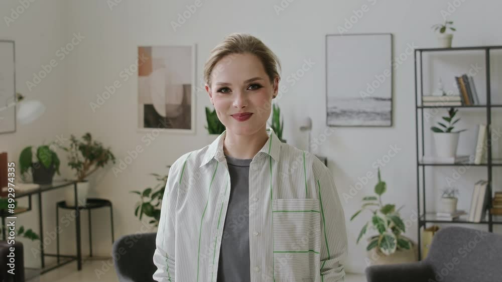 Medium POV portrait of cheerful young Caucasian woman with hearing disability saying phrase, I love you, in American sign language, with hand gesture, looking at camera, smiling and winking