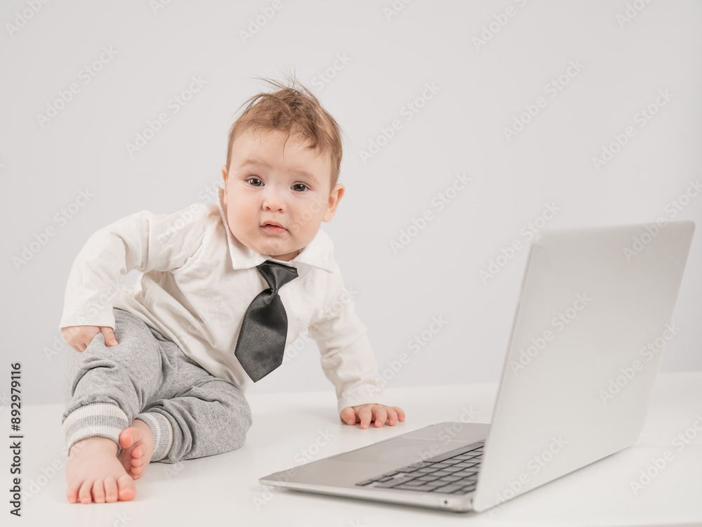 Cute baby boy in a tie working at a laptop. Cute baby boy in a tie working at a laptop.