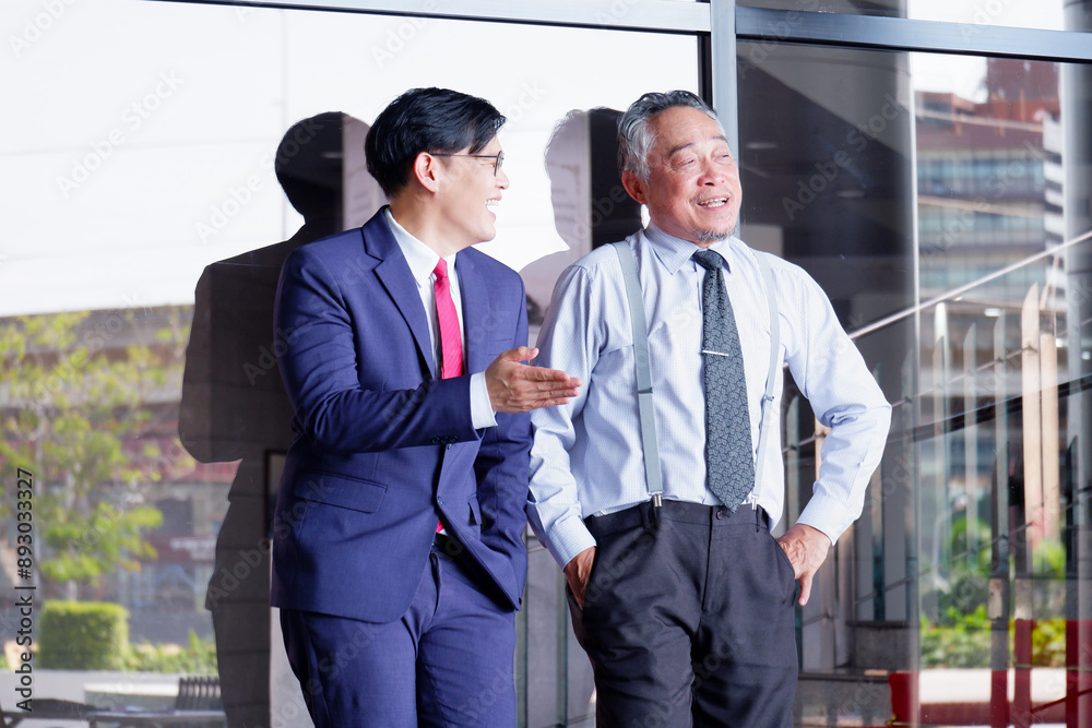 Male businessman standing and smiling inside the office. Male businessman standing and smiling inside the office.