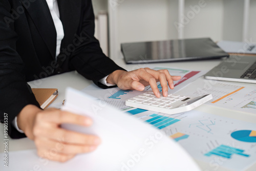 Professional Accountant analysis Financial Reports and Using Calculator in Modern Office Setting