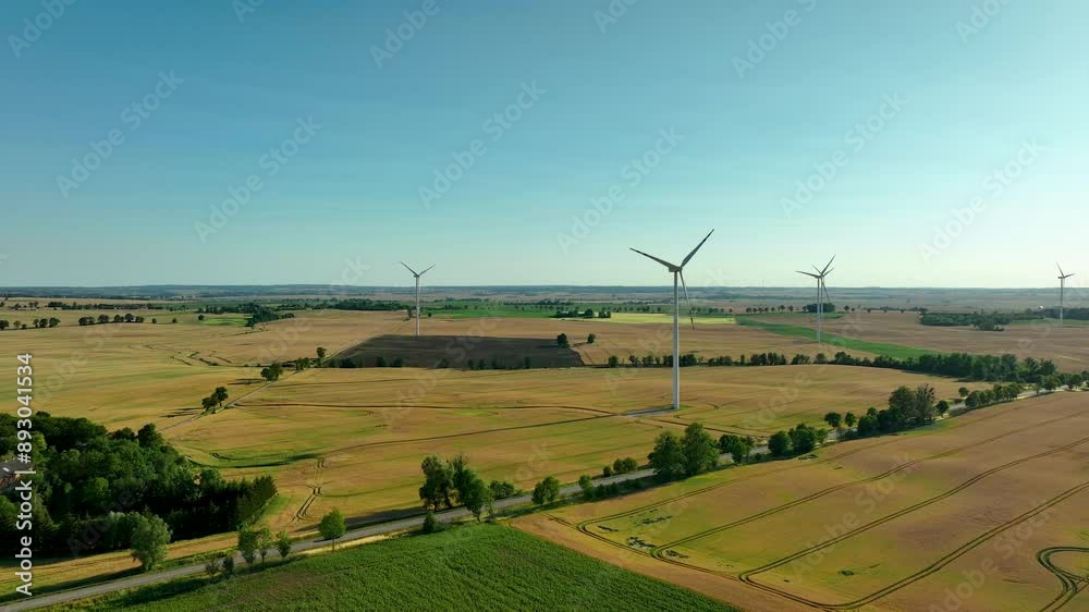 Wind turbines standing tall in expansive agricultural fields, captured ...