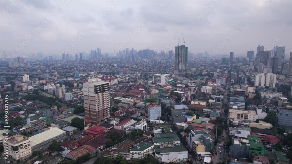 Manila philippines on a grey cloudy day showing the epic skyline and smaller suburbs below split up by skyscrapers, roads, and tres