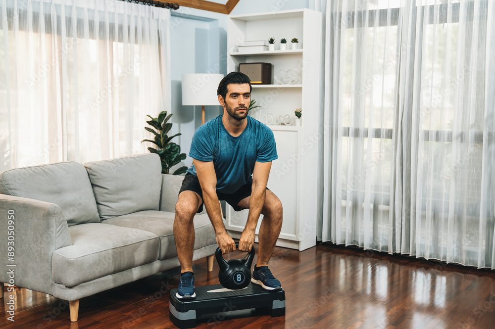 Athletic body and active sporty man doing squat with kettlebell weight for effective targeting muscle gain at gaiety home as concept of healthy fit body home workout lifestyle. Athletic body and active sporty man doing squat with kettlebell weight for effective targeting muscle gain at gaiety home as concept of healthy fit body home workout lifestyle.